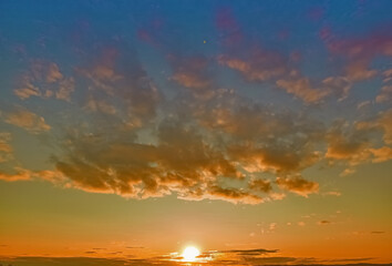 Beautiful sunset over the horizon against a background of white clouds