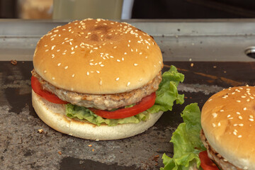 Regular freshly prepared street burger with a patty and vegetables. Close-up