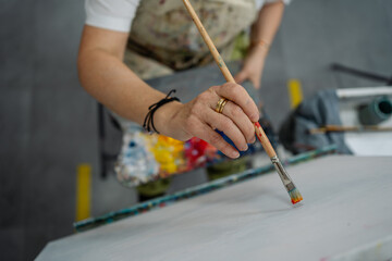Artist starts painting on canvas at art workshop