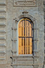 Grey Stone Building Wall with an Arched and Shuttered  Window .