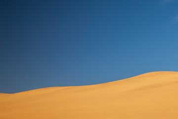 Sand dune with large blue sky
