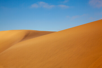 Sand dunes in Namibia under  a blue sky