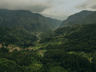 A stunning view of the first rays of the sun bathing the rugged peaks of the madeira mountains in a golden glow, highlighting the spectacular natural topography