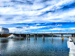 Beneath a beautifully designed Modern Bridge that stands over peaceful and calm water,
