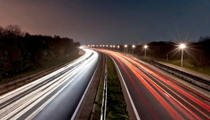 A winding road through lush green hills at sunset with vibrant lights illuminating the road ahead