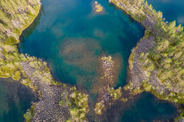 Lakes with rocky shores in the middle of a forest is a typical glacial landscape of the Republic of Karelia, northwest Russia. Uksinsky esker ridge. Aerial view