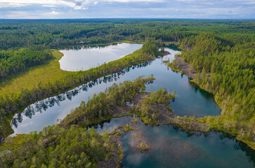 Lakes with rocky shores in the middle of a forest is a typical glacial landscape of the Republic of Karelia, northwest Russia. Uksinsky esker ridge. Aerial view