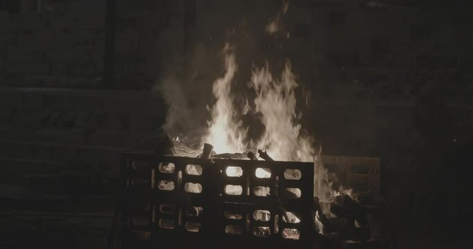 Varanasi, Uttar Pradesh, India. Cremation on Manikarnika Ghat. night lights. Fire, smoke - Funeral rites of cremation close up