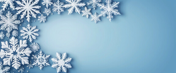 Snowflakes of different sizes and shapes creating a winter frame on a light blue background with a brighter central area. Christmas template.