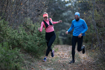 trail running with a sporty couple in the magic forest in early morning