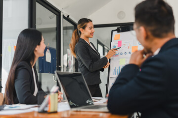 Professional woman presenting data in meeting with colleagues, showcasing charts and graphs. atmosphere is focused and collaborative, highlighting teamwork and communication