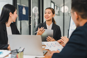 Professional women discussing business strategies in modern office setting, showcasing teamwork and collaboration. Their expressions reflect engagement and positivity