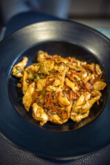 Delicious looking pasta with chicken, vegetables and sauce cooked in the restaurant.