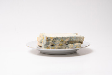 moldy or rotten bread on plate, expired bread or contaminated food