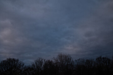 Naklejka premium A dense, overcast sky at early morning with dark clouds covering the scene.