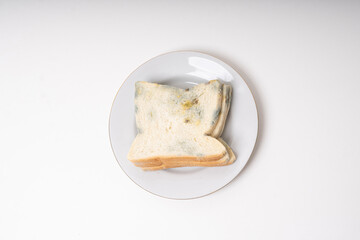 moldy or rotten bread on plate, expired bread or contaminated food