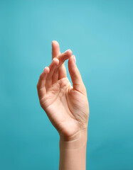 Close up Female hand holding something isolated on light blue