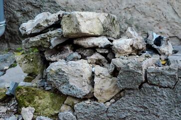 A pile of rocks is sitting on the ground. The rocks are grey and white, and they appear to be broken and scattered. The scene gives off a sense of decay and abandonment.