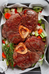 fried meat on the bone, raw, chopped vegetables, ingredients in the oven, for cooking ossobuco, top view, no people,