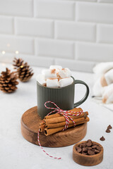 New Year cocoa mug with marshmallows and cinnamon on round board