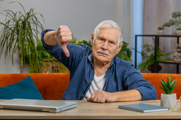 Dislike. Upset unhappy senior old man showing thumbs down sign gesture, expressing discontent,...