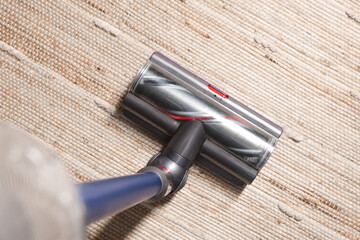Cleaning carpet with cordless vacuum cleaner indoors, top view
