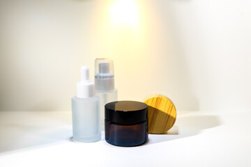 Cosmetic mockup - jars for cream, essential oil bottle of amber glass on Minimalist amber glass dropper bottle for essential oils, skincare serums, or cosmetic products isolated on white background