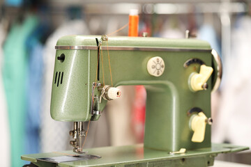 Vintage sewing machine with thread in workshop, closeup