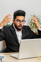 Displeased Indian businessman programmer software developer working on laptop loses becoming...