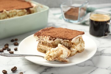 Piece of tasty tiramisu on white marble table, closeup