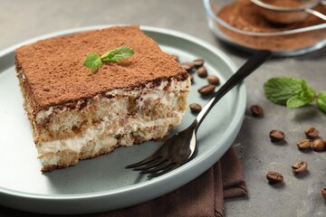 Piece of tasty tiramisu on grey table, closeup