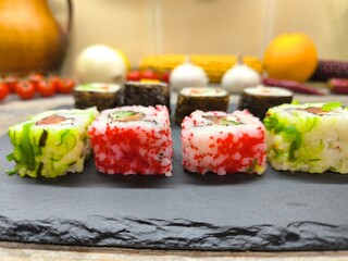 Delicious sushi rolls on a granite chopping board.