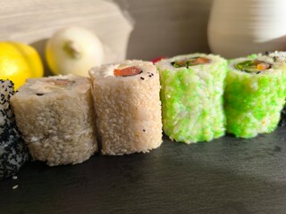 Delicious sushi rolls on a granite chopping board.