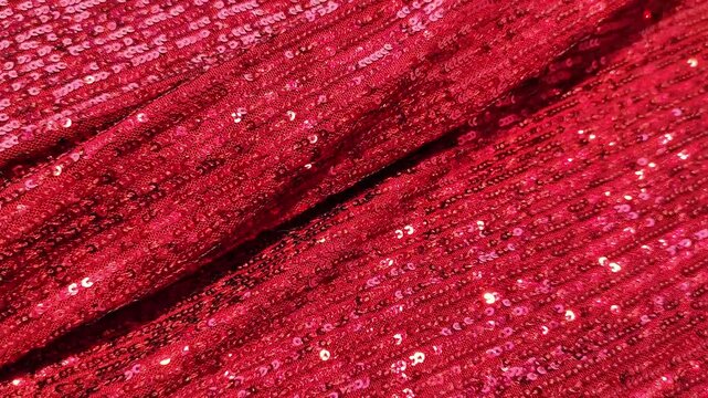 Rich red sequin fabric with a reflective, shimmering texture and slight folds creating a luxurious look