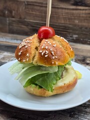 homemade hamburgers with tomato on a white plate