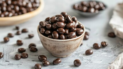 Fototapeta premium Chocolate-covered espresso beans in a small ceramic bowl, great for coffee lovers
