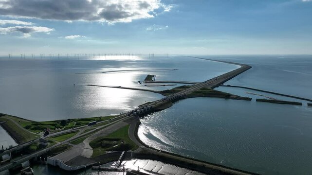 Aerial video of the Dutch afsluitdijk, a man made dike construction between Noord-Holland and Friesland, acting as flood protection barrier and segregating the IJsselmeer from the North Sea