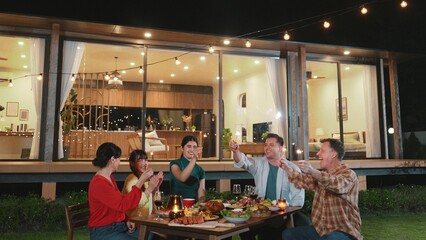 Happy family holding glowed sparkler in holiday celebration party at night. Lovely member enjoy...