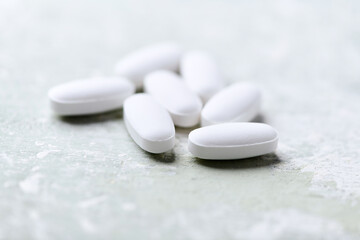 White tablets on wooden background. Soft focus. Close up. Copy space