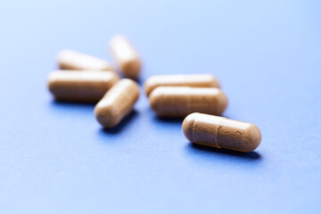 Korean Ginseng capsules. Concept for a healthy dietary supplementation. Bright paper background. Close up.