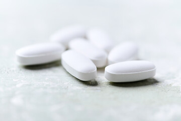 White tablets on wooden background. Soft focus. Close up. Copy space