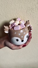 Christmas cup of cocoa and marshmallows held in hand. Vertical foto