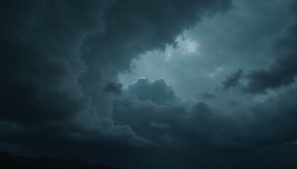 Obraz premium Dramatic dark cloudy sky with swirling clouds and a hint of light peeking through the darkness