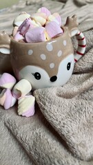 cup of hot drink with marshmallows in the shape of a Christmas deer. vertical photo