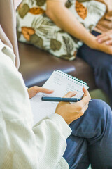 Woman holding book and pen in interview