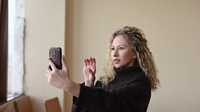 Caucasian woman teaches English sign language via video link. 