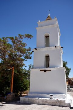 The Campanario de San Lucas. 17th Century Belltower under a blue sky, getting a coat of white paint. Toconao, San Pedro de Atacama, Antofagasta, Chile, October 14, 2023.