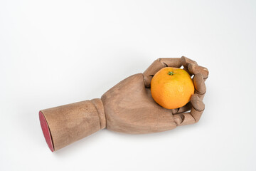 a mandarin in the palm of a wooden hand