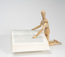 a wooden dummy reading a book