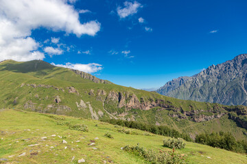 Fototapeta premium Caucasian mountains near Gergeti village, Stepansminda. Kazbegi mountain behind the clouds. Georgia